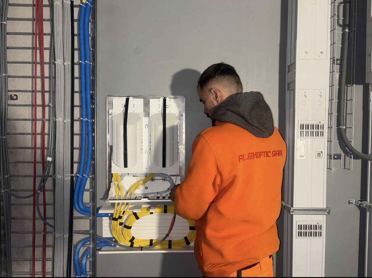 Technicien FlexOptic réalisant un raccordement dans un BEP
